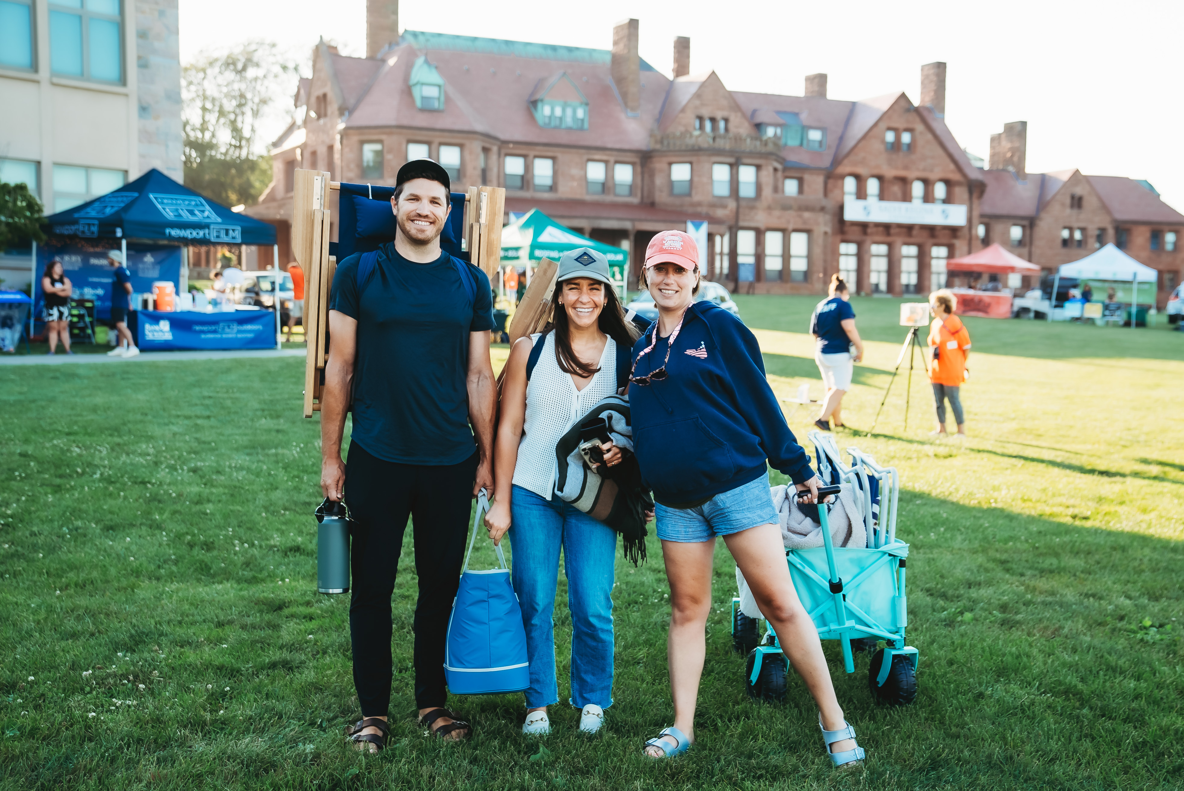 Three people standing on lawn, smiling at newportFILM event